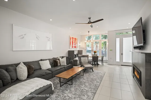 a living room with furniture a flat screen tv and kitchen view