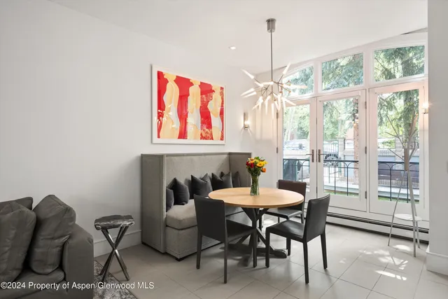 a dining room with furniture a chandelier and window
