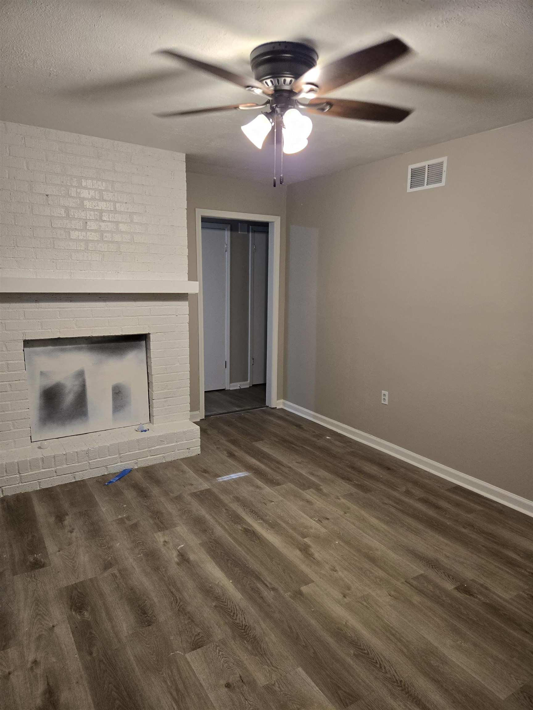 4378 Shadcrest Road Memphis, TN 38128 - Photo 3 of 5 a view of an empty room with a fireplace and a chandelier fan