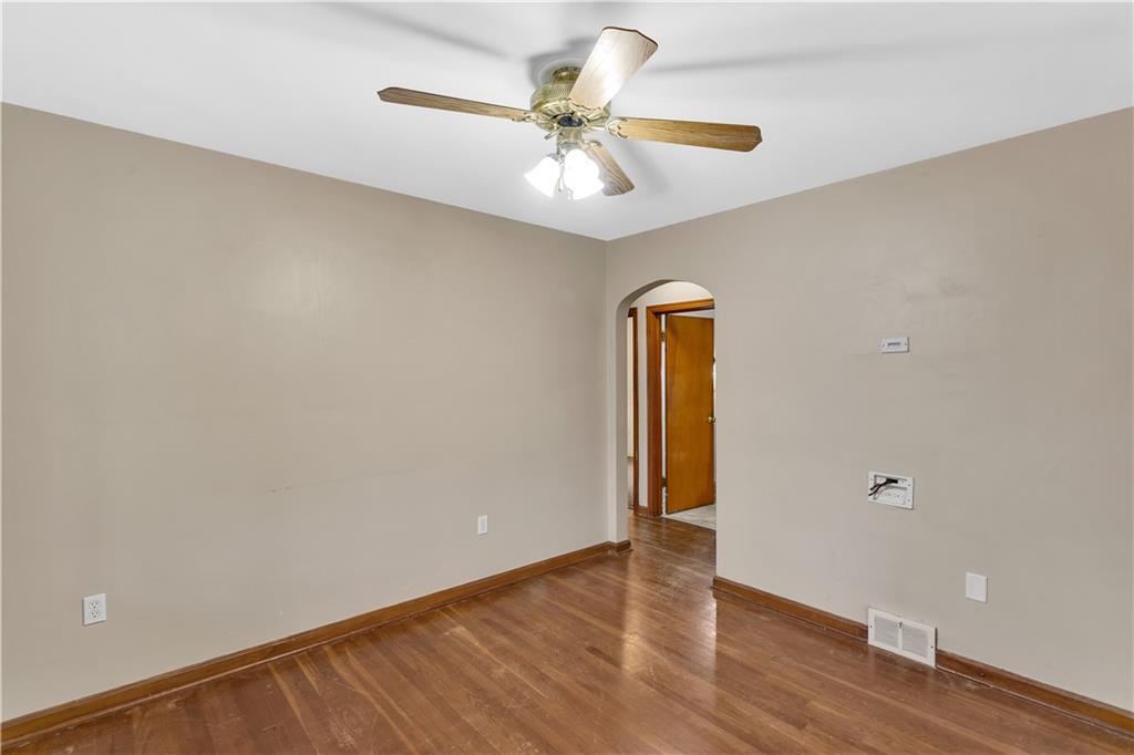 1710 Ridge Rd Extension Ambridge, PA 15003 - Photo 7 of 31 an empty room with wooden floor chandelier fan and windows