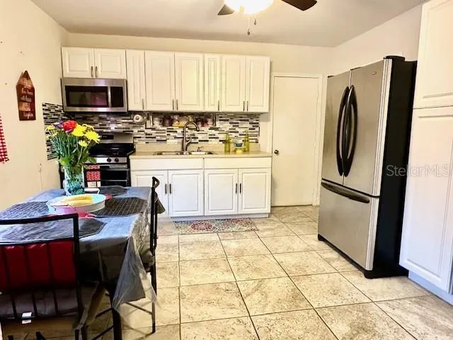 a kitchen with a refrigerator sink and cabinets