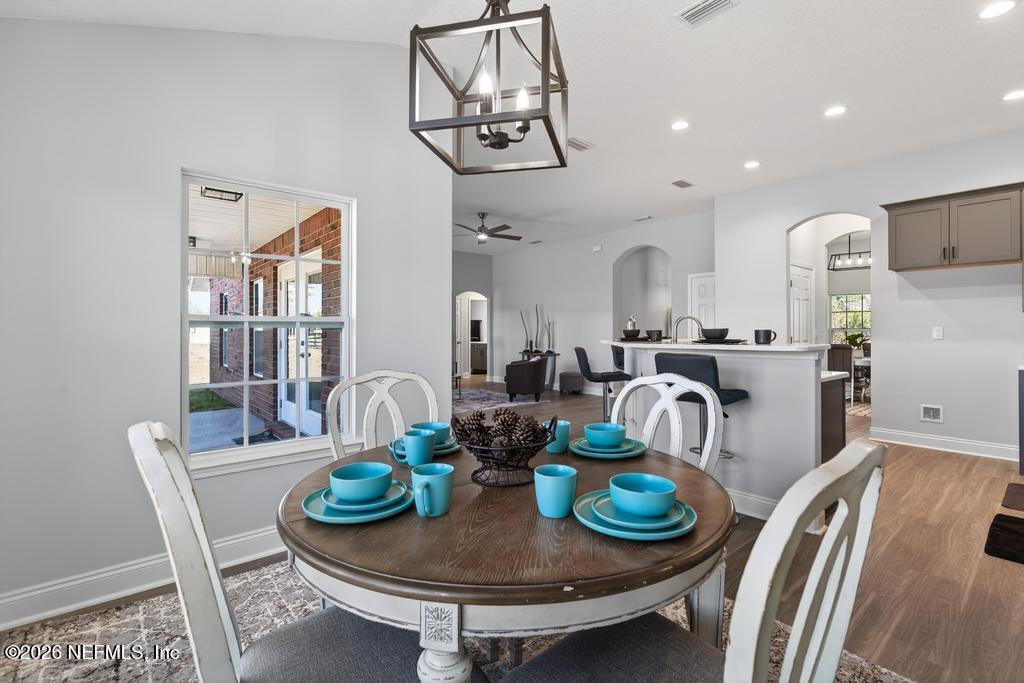 55225 Bartram Trail Callahan, FL 32011 - Photo 25 of 69 a dining room with furniture a chandelier and wooden floor