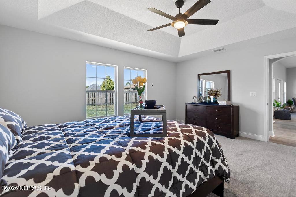 55225 Bartram Trail Callahan, FL 32011 - Photo 44 of 69 a bedroom with a bed and a chandelier