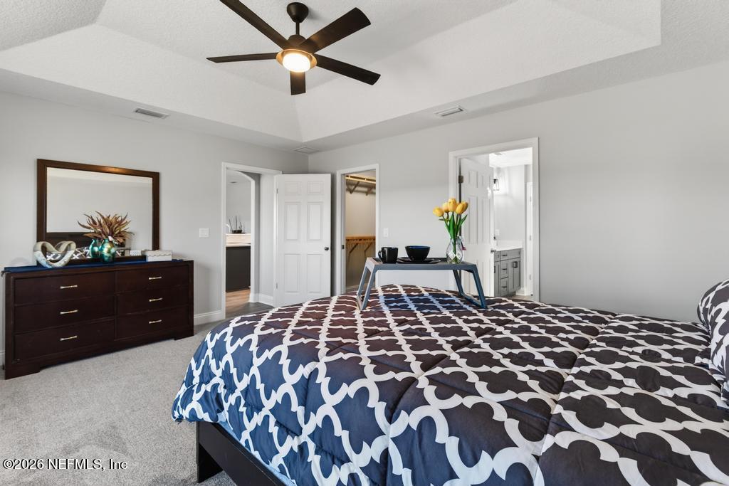 55225 Bartram Trail Callahan, FL 32011 - Photo 46 of 69 a bedroom with a large bed and a chandelier