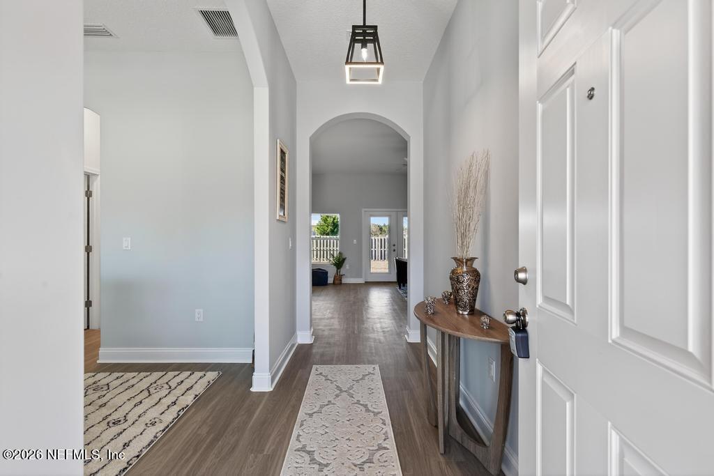 55225 Bartram Trail Callahan, FL 32011 - Photo 8 of 69 a view of a hallway with wooden floor and a living room