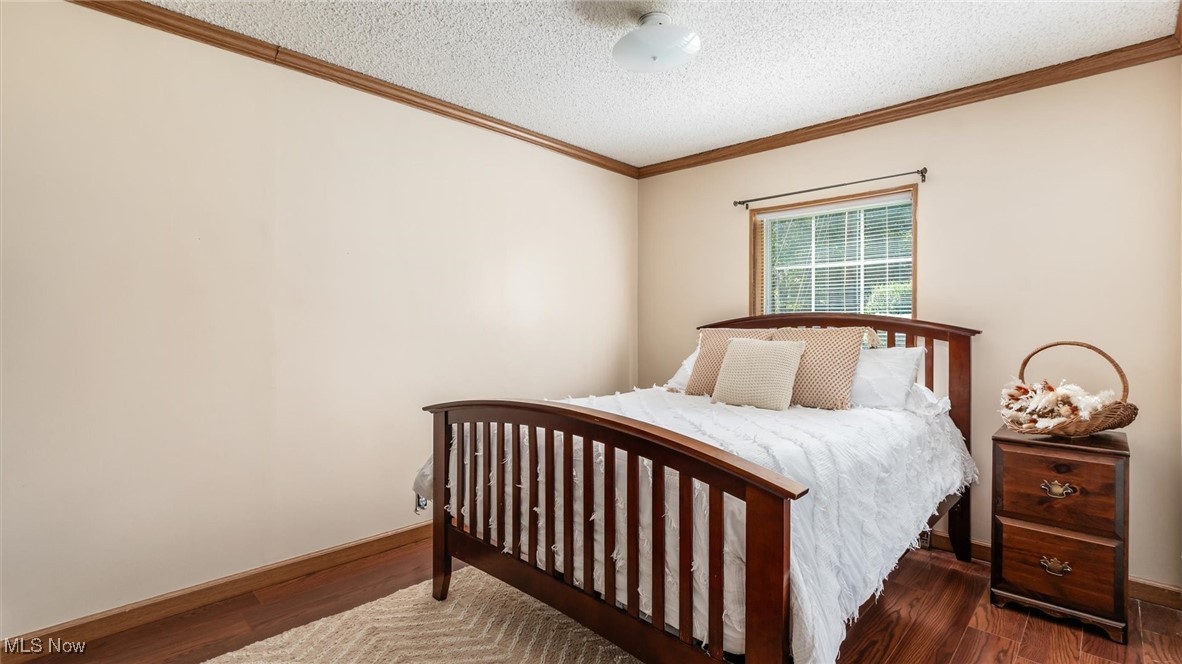 13306 Fairview Road Southeast Newark, OH 43056 - Photo 24 of 48 Bedroom with crown molding, dark wood finished floors, and a textured ceiling