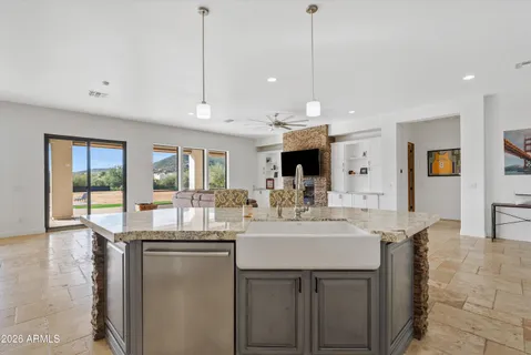 a kitchen with kitchen island granite countertop a sink stainless steel appliances and white cabinets