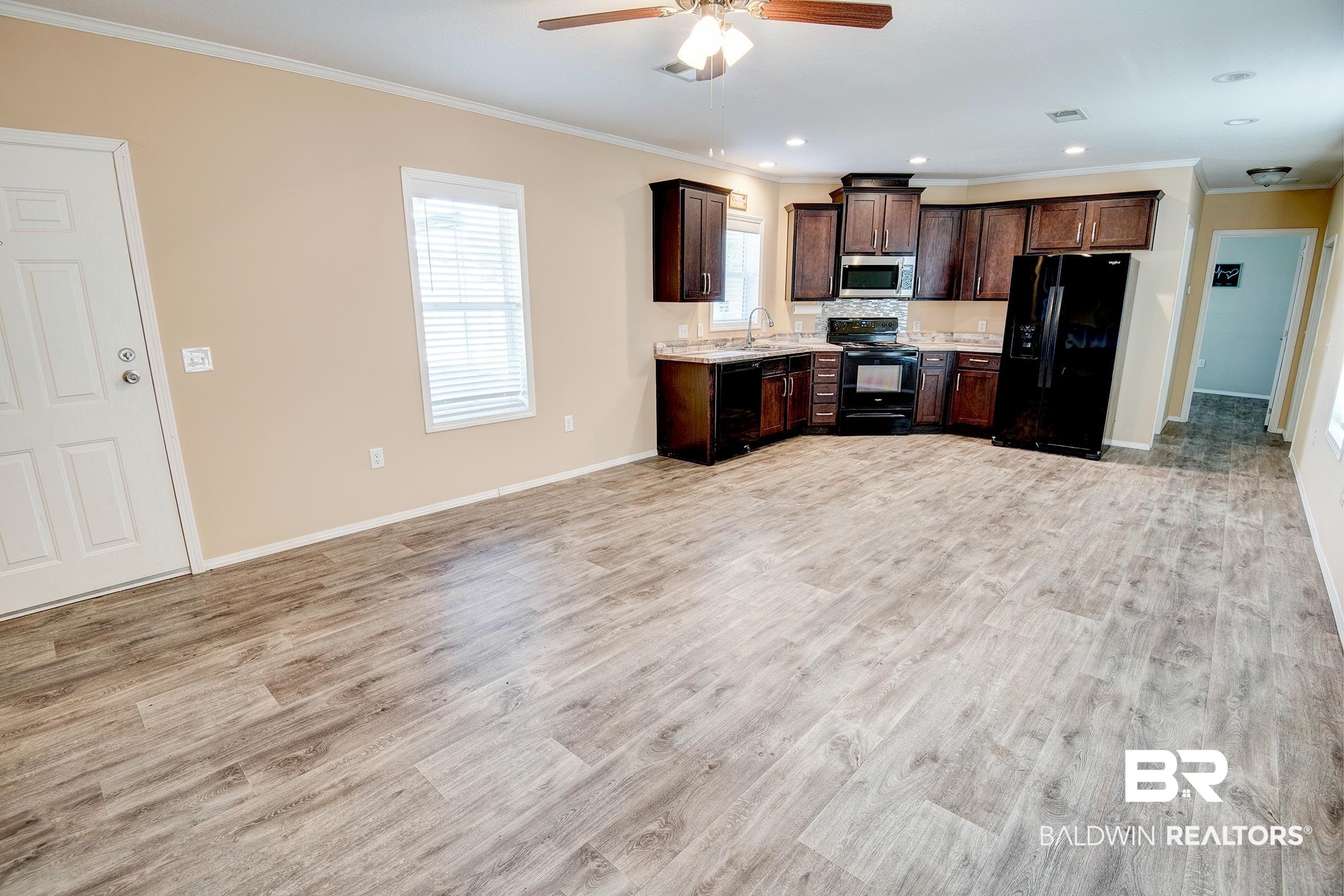 21859 West Side Loop Silverhill, AL 36576 - Photo 13 of 24 Kitchen featuring black appliances, light hardwood / wood-style flooring, crown molding, and dark brown cabinets