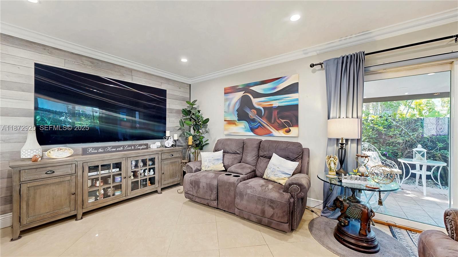 982 Northwest 133rd Court Miami, FL 33182 - Photo 12 of 22 a living room with furniture a flat screen tv and floor to ceiling window