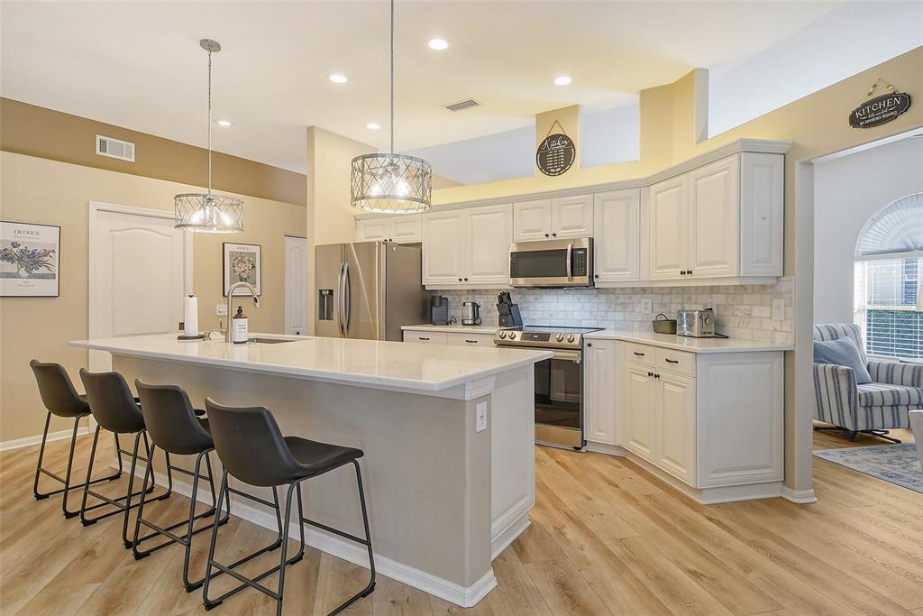 6738 Pleasant Hill Road Bradenton, FL 34203 - Photo 16 of 93 a kitchen with stainless steel appliances granite countertop a sink a stove a refrigerator and island with wooden floor