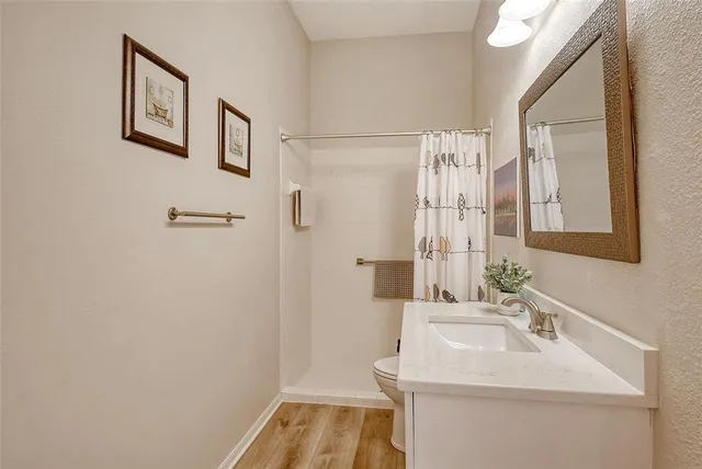 a view of a house next to a big yard and large trees