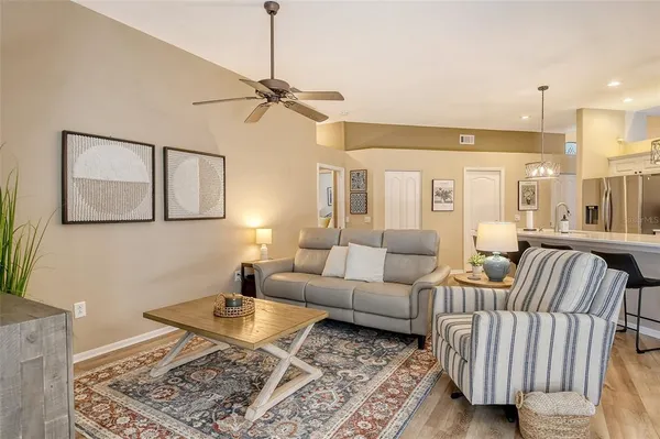 a large kitchen with stainless steel appliances kitchen island granite countertop a table chairs and a refrigerator