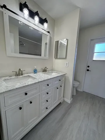 a bathroom with a double vanity sink and mirror