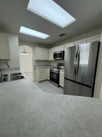 a kitchen with stainless steel appliances granite countertop a refrigerator a stove a sink and a dishwasher