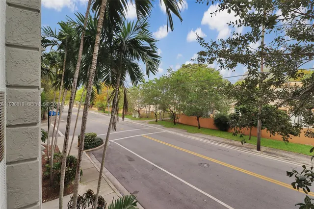 a front view of a house with a garden and trees