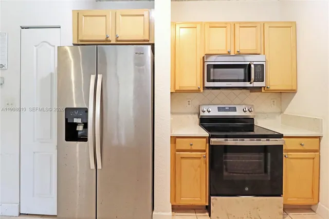 a kitchen with stainless steel appliances a stove microwave and refrigerator