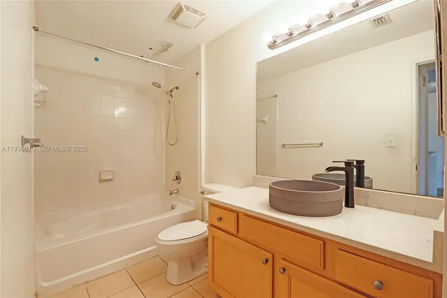 a bathroom with a granite countertop sink a toilet and shower