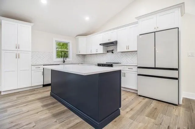 a kitchen with granite countertop white cabinets and white appliances