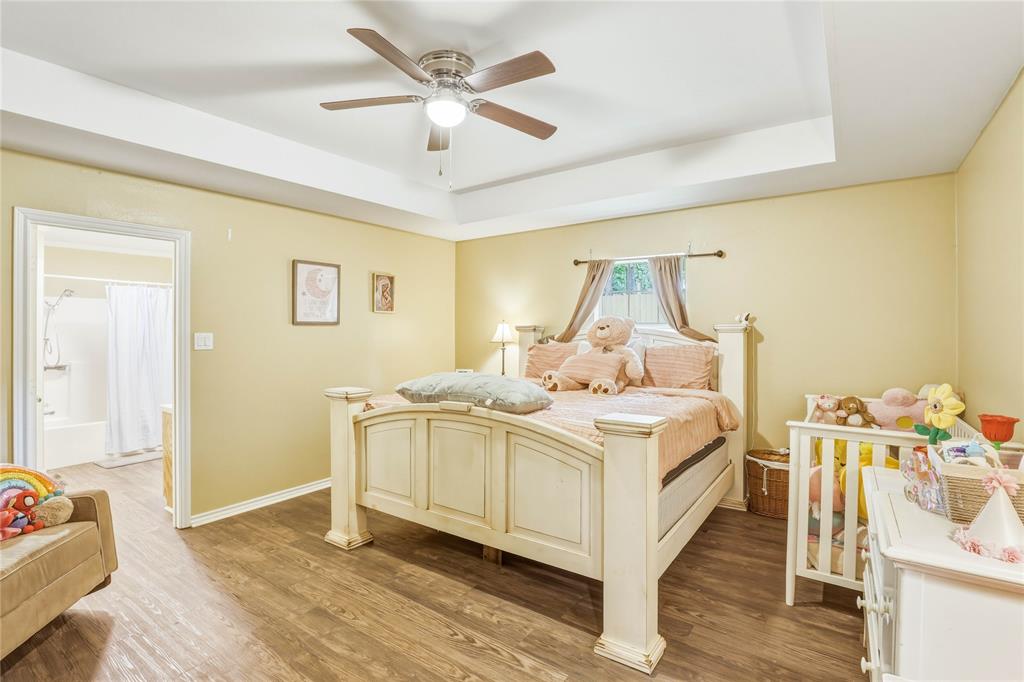 110 Peggy Ruth Drive Longview, TX 75605 - Photo 13 of 27 Bedroom featuring wood-finish flooring, a tray ceiling, and a ceiling fan with integrated lighting