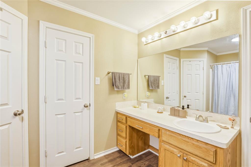 110 Peggy Ruth Drive Longview, TX 75605 - Photo 17 of 27 Bathroom vanity featuring an integrated sink, laminate countertop, and wood-finish cabinetry