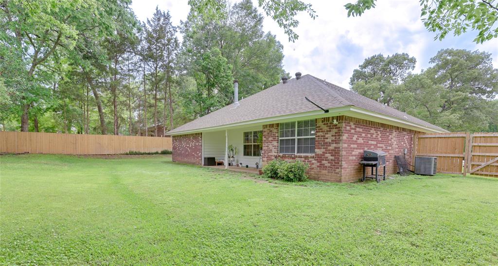 110 Peggy Ruth Drive Longview, TX 75605 - Photo 2 of 27 Expansive backyard with a manicured lawn, full perimeter wood fencing, and a brick exterior with white trim