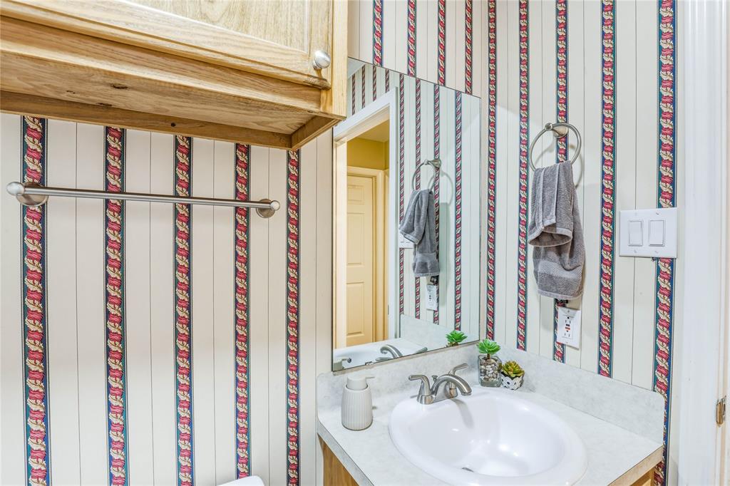 110 Peggy Ruth Drive Longview, TX 75605 - Photo 23 of 27 Bathroom vanity featuring a white oval sink, brushed nickel faucet, and a large mirror