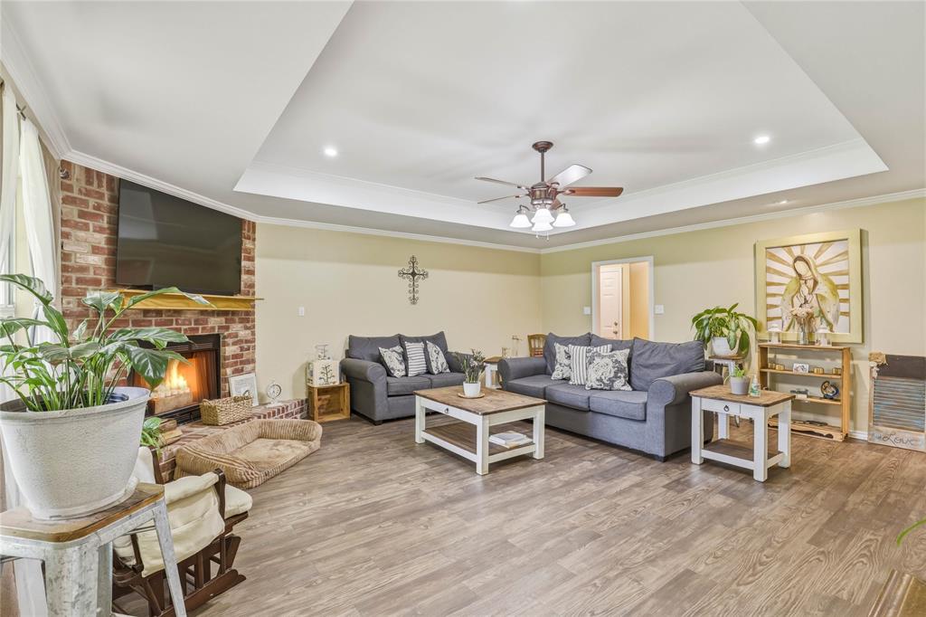 110 Peggy Ruth Drive Longview, TX 75605 - Photo 8 of 27 Spacious living area featuring a brick fireplace with a wood mantel, tray ceiling, recessed lighting, and wood-finish flooring
