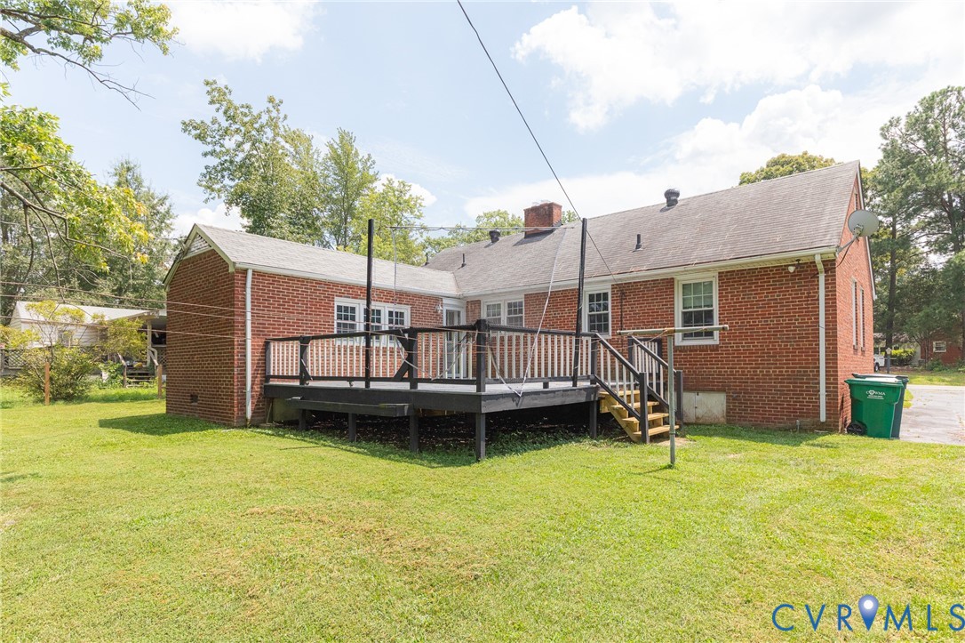 8728 Holly Hill Road Henrico, VA 23229 - Photo 30 of 36 Back of house with a wooden deck, a lawn, brick si