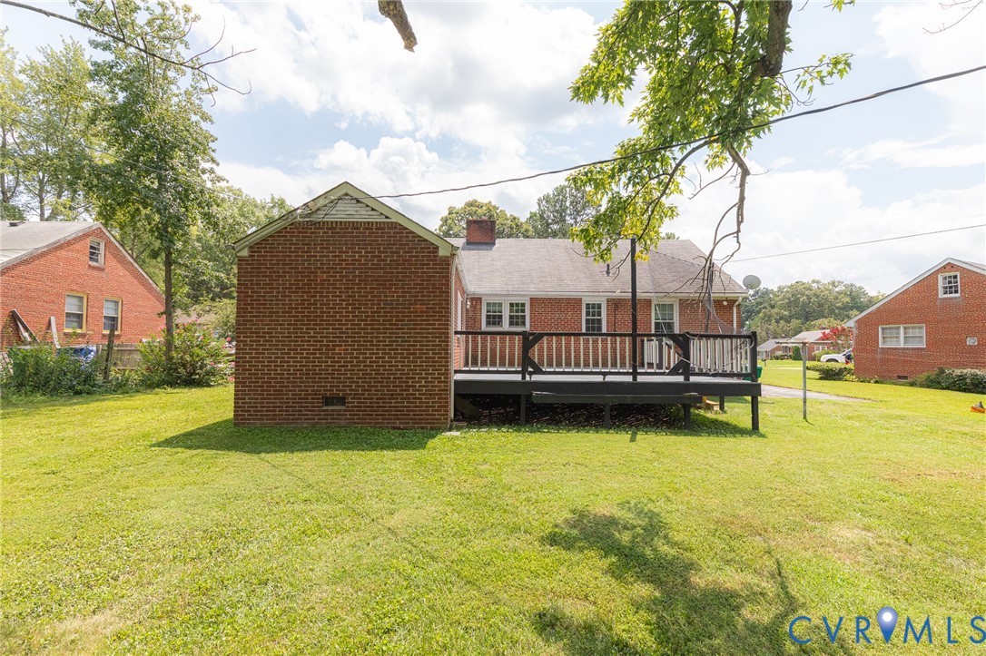 8728 Holly Hill Road Henrico, VA 23229 - Photo 32 of 36 Back of house featuring a deck, a chimney, a lawn,