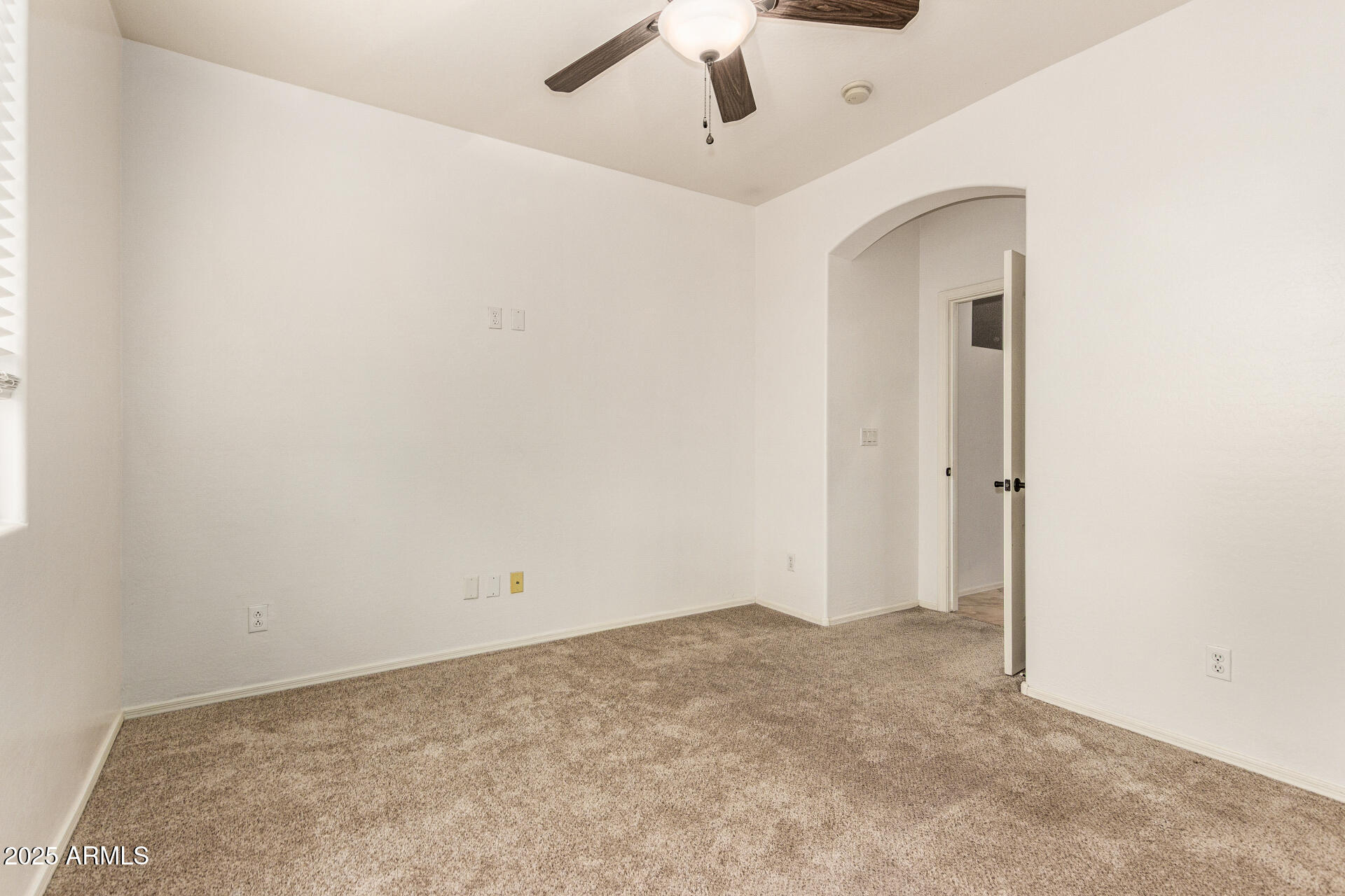 9228 West Black Hill Road Peoria, AZ 85383 - Photo 25 of 44 an empty room with a ceiling fan and carpet