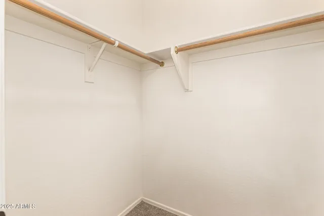 an empty room with a ceiling fan and carpet