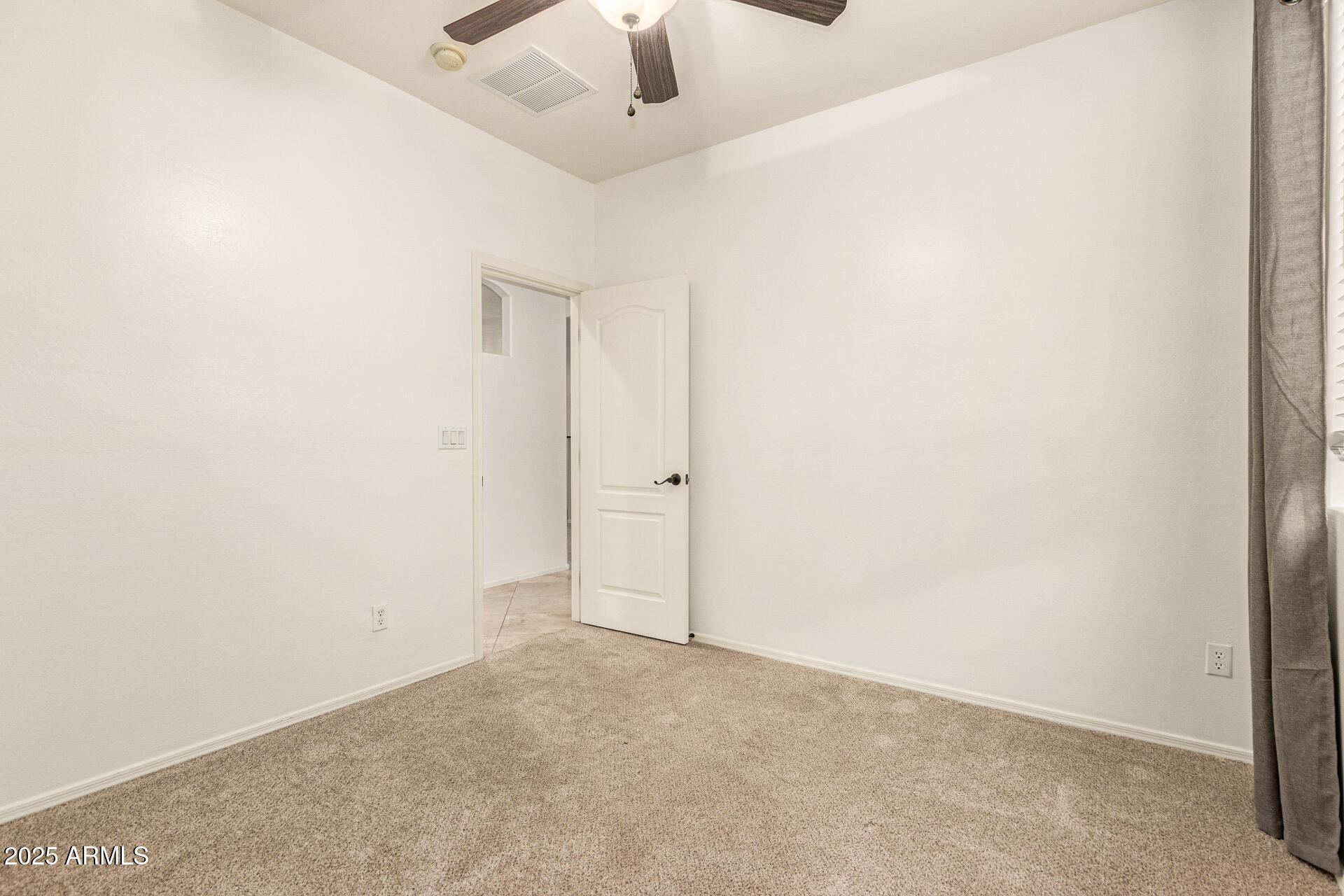 9228 West Black Hill Road Peoria, AZ 85383 - Photo 28 of 44 an empty room with a ceiling fan and carpet