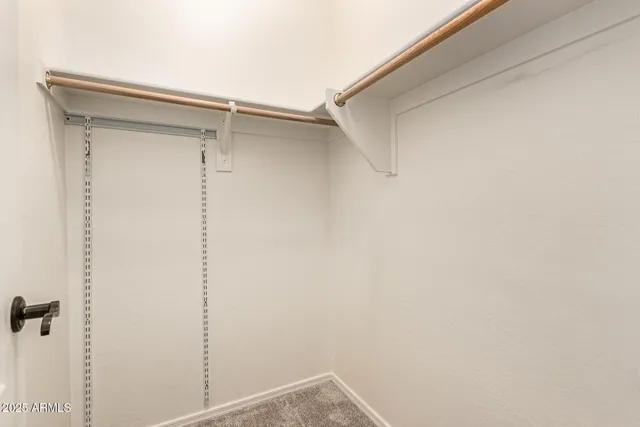 an empty room with a ceiling fan and carpet