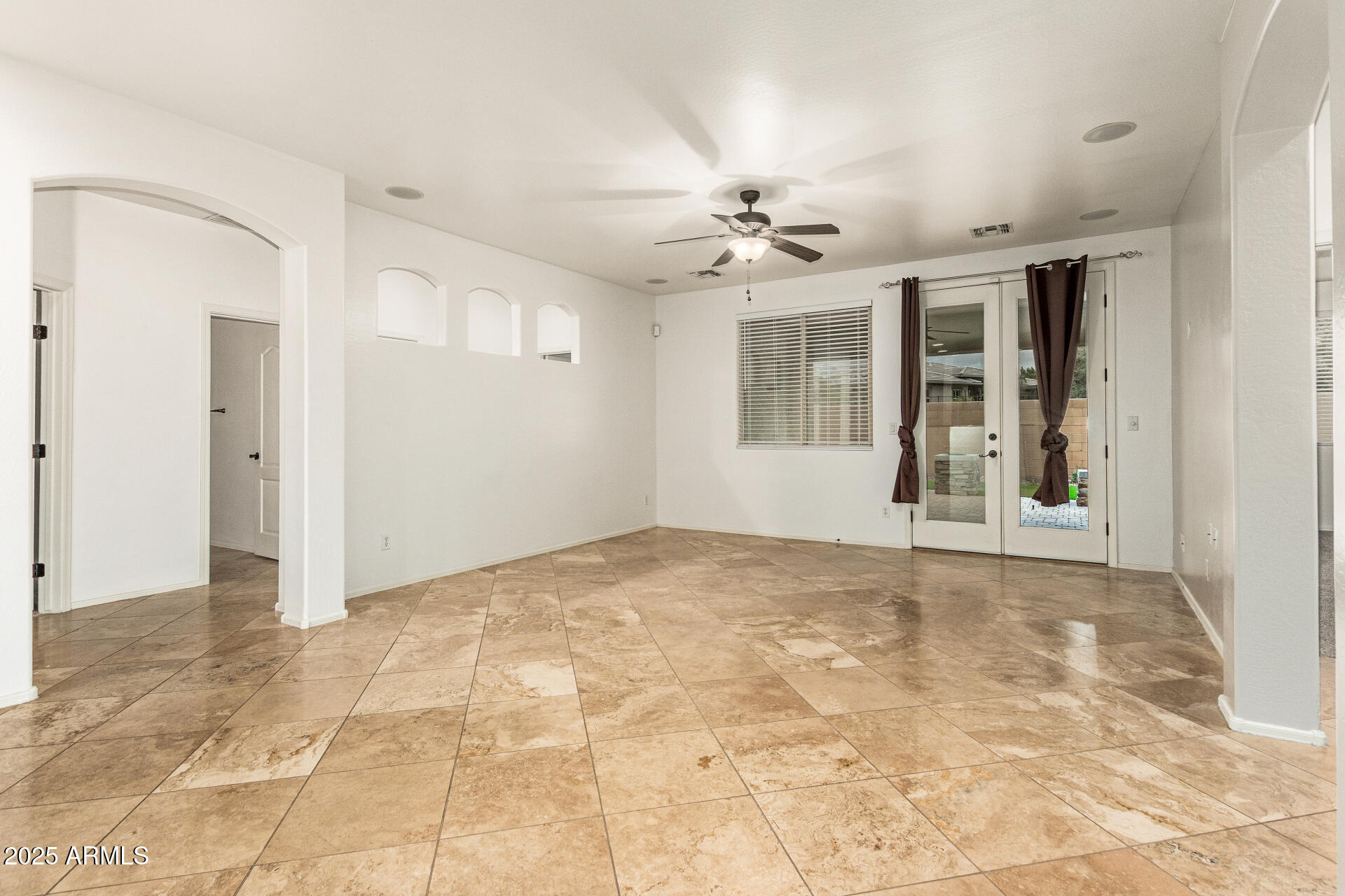 9228 West Black Hill Road Peoria, AZ 85383 - Photo 7 of 44 a view of an empty room with chandelier fan and windows