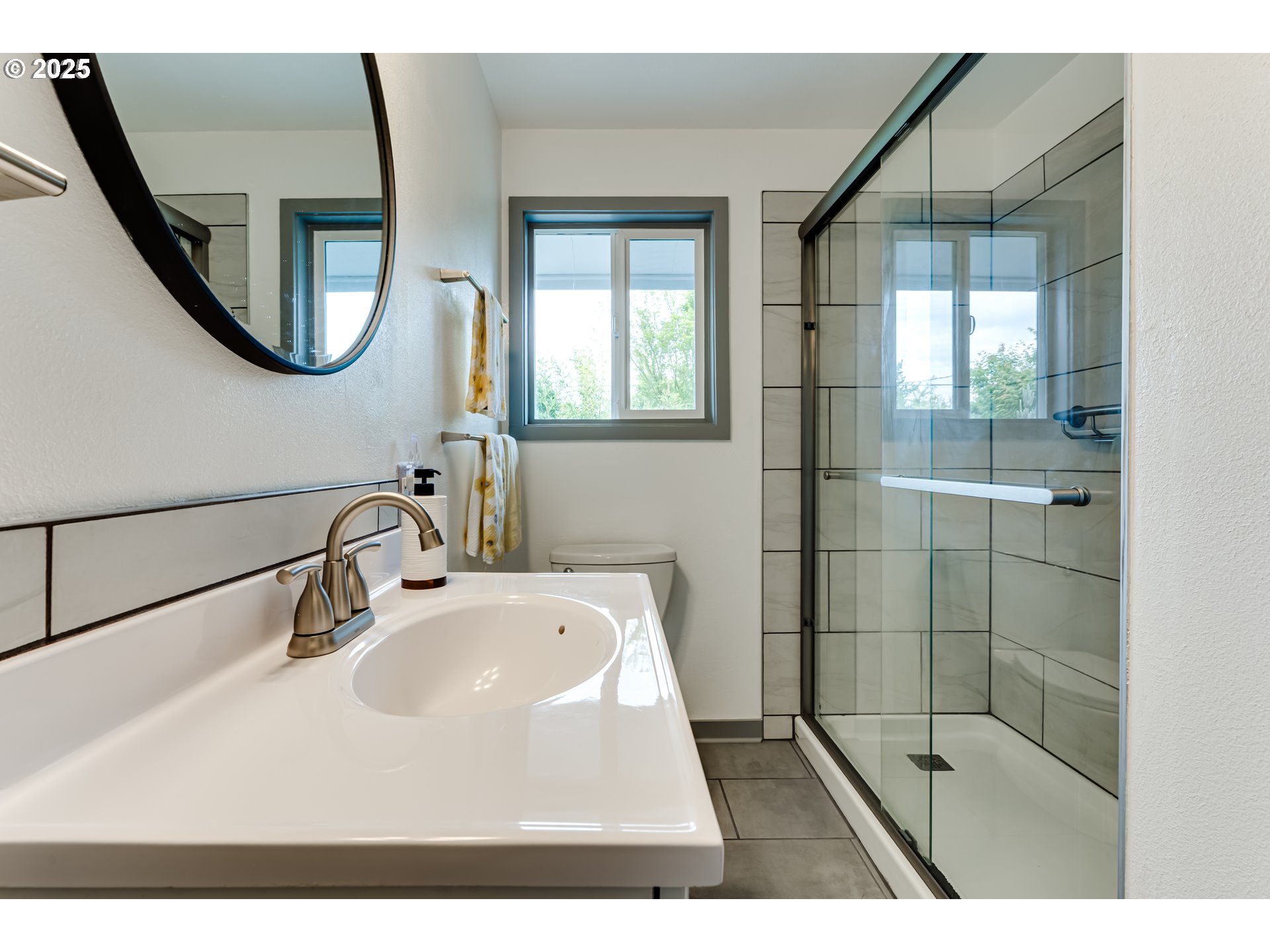3140 Onyx Street Eugene, OR 97405 - Photo 15 of 32 a bathroom with a sink a mirror and a shower