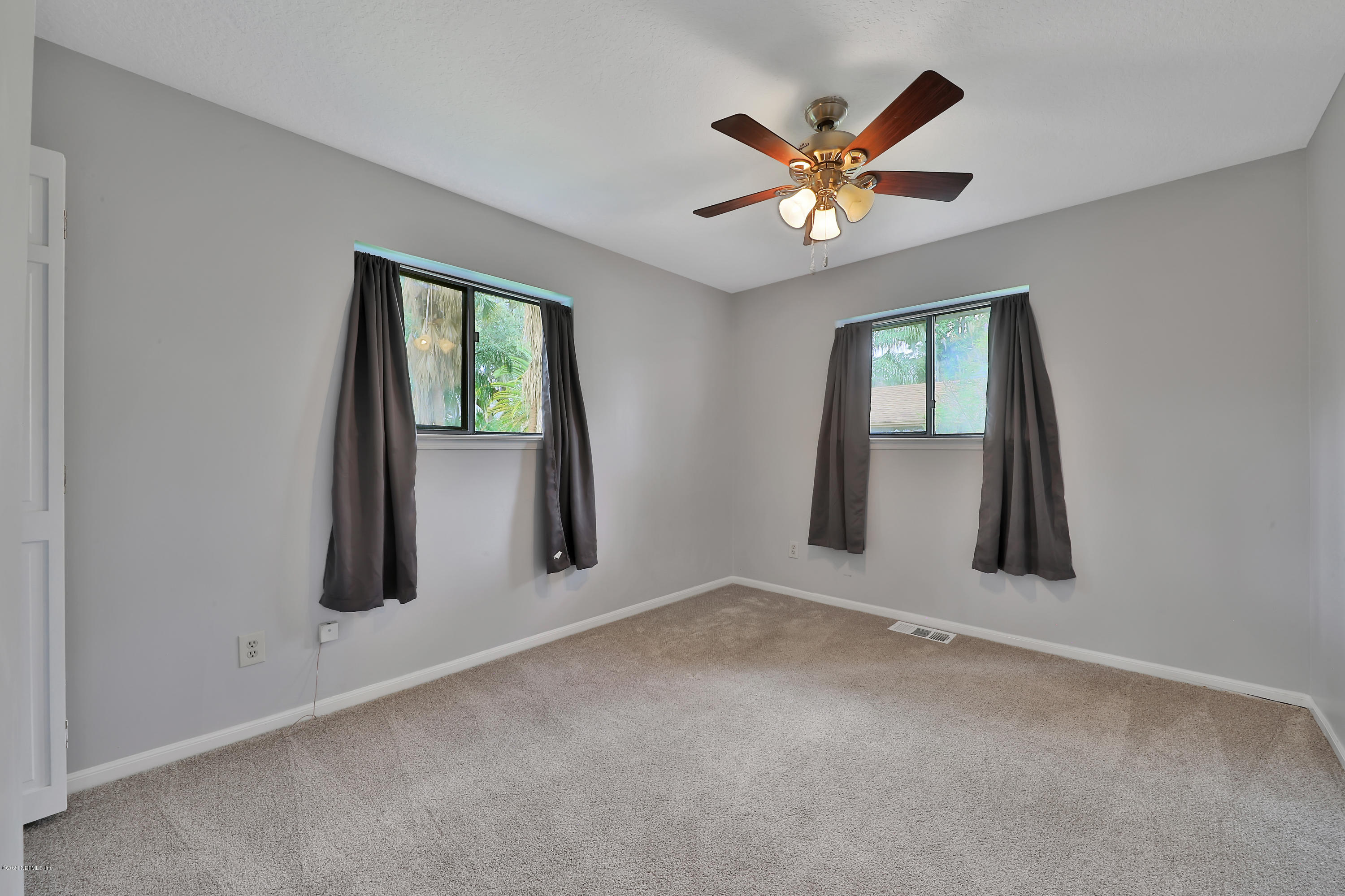 1350 Pinewood Road Jacksonville Beach, FL 32250 - Photo 21 of 45 an empty room with window and ceiling fan