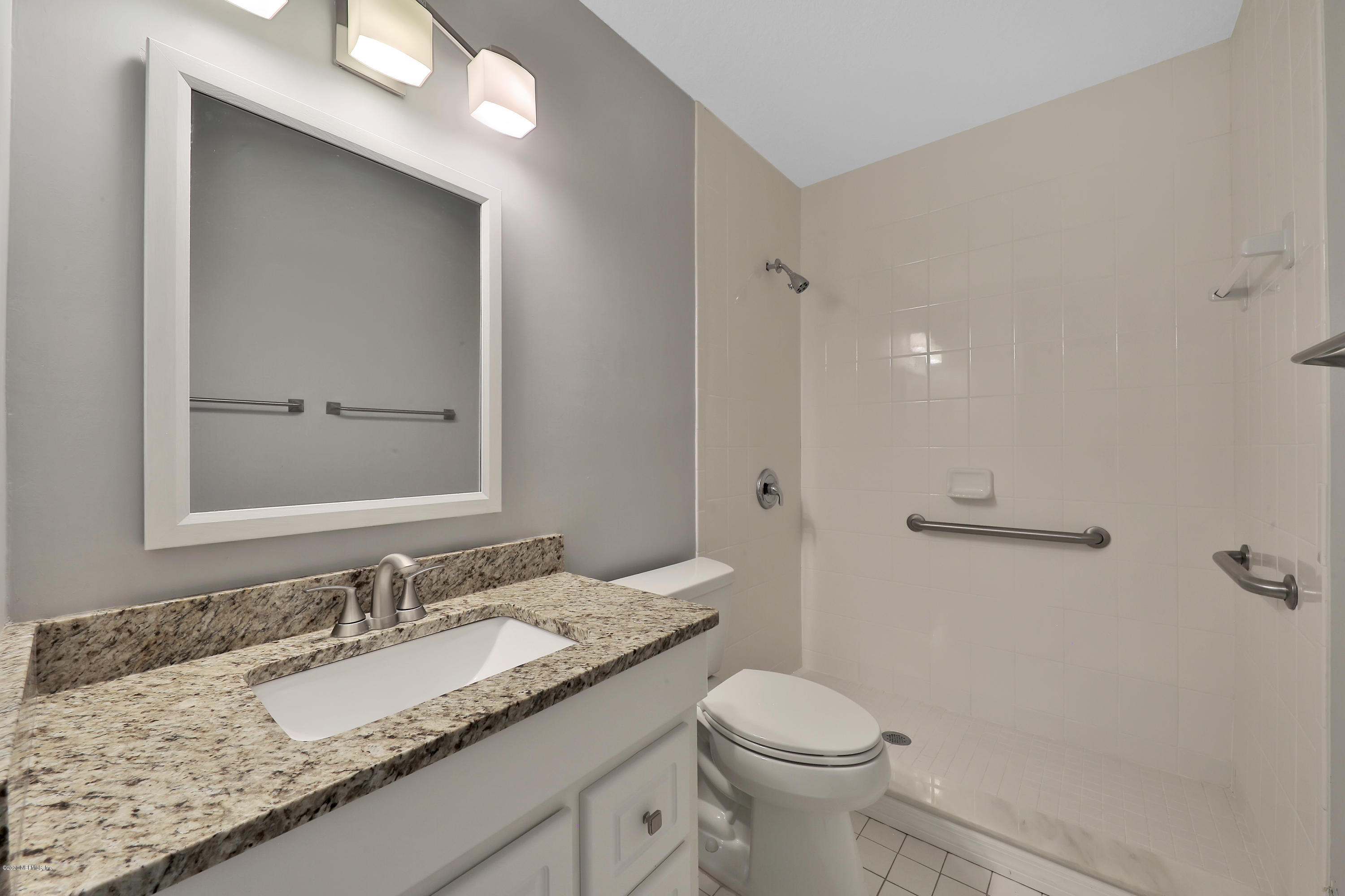 1350 Pinewood Road Jacksonville Beach, FL 32250 - Photo 22 of 45 a bathroom with a granite countertop sink and a mirror