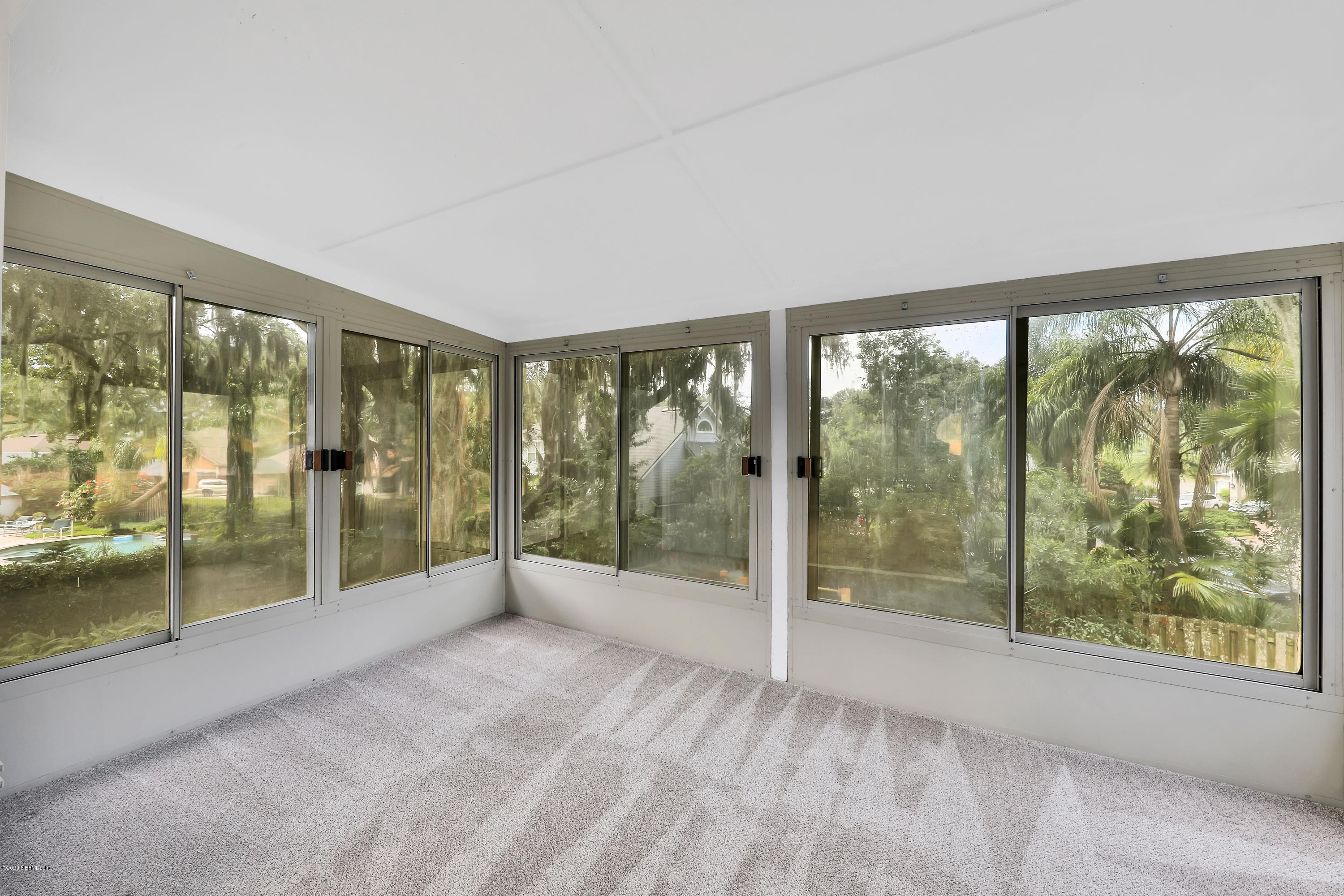1350 Pinewood Road Jacksonville Beach, FL 32250 - Photo 32 of 45 a view of an empty room with wooden floor and a balcony