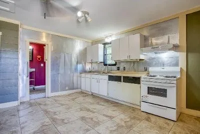 a kitchen with granite countertop white cabinets and white appliances