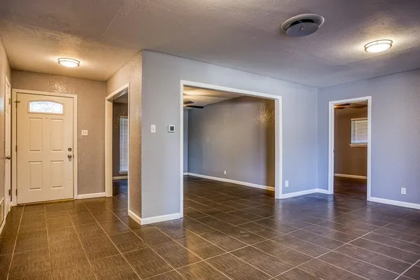 an empty room with wooden floor and mirror