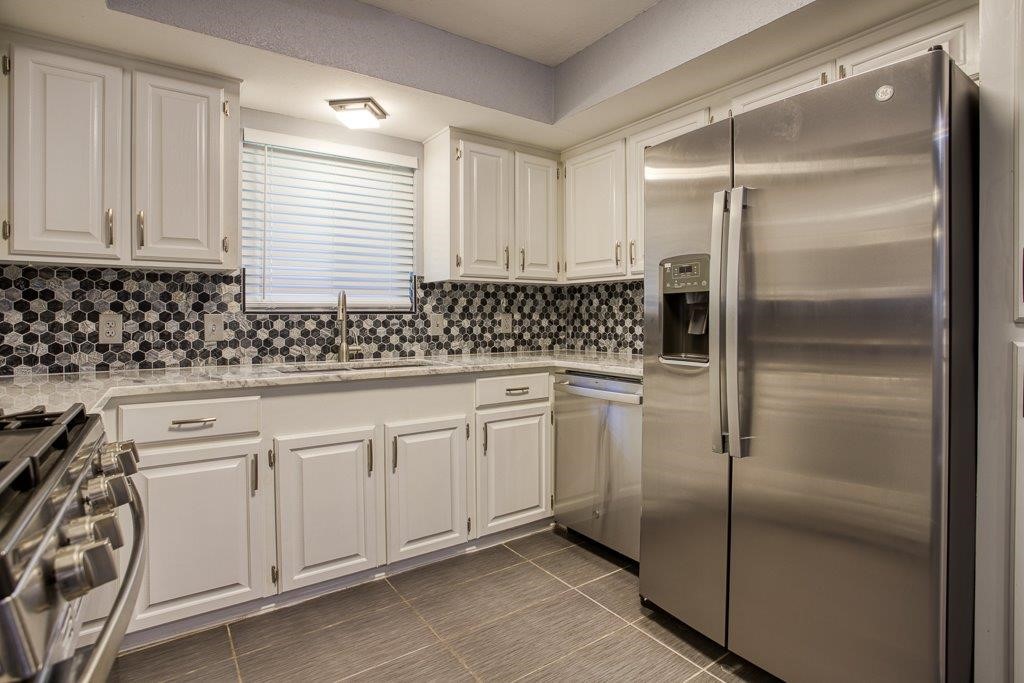10733 Timbergrove Lane Corpus Christi, TX 78410 - Photo 6 of 40 a kitchen with white cabinets sink and refrigerator