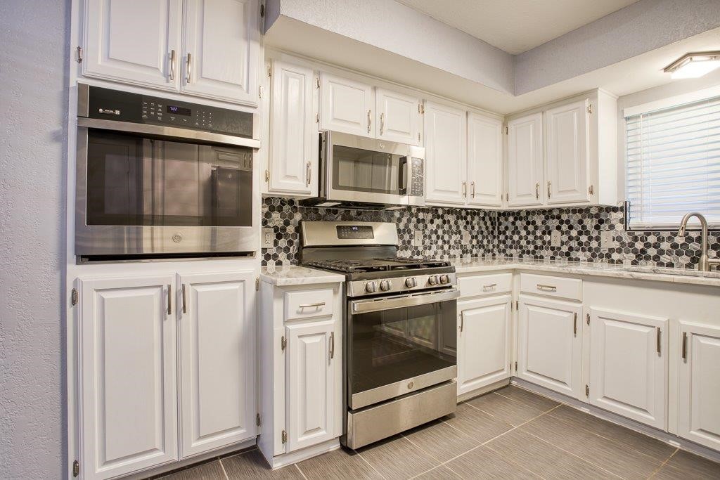 10733 Timbergrove Lane Corpus Christi, TX 78410 - Photo 7 of 40 a kitchen with stainless steel appliances granite countertop white cabinets and stove
