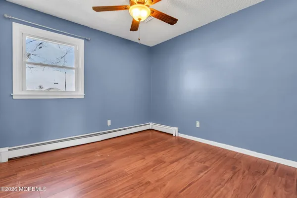 an empty room with a window and a ceiling fan