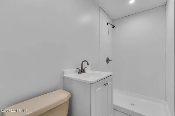 a bathroom with a sink a toilet and shower