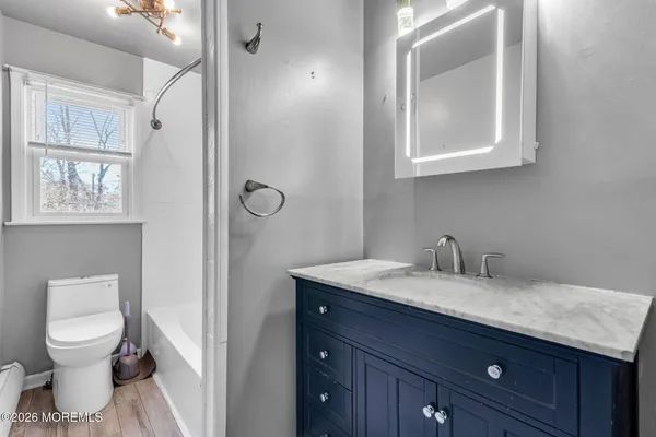 a bathroom with a granite countertop sink a toilet and a mirror