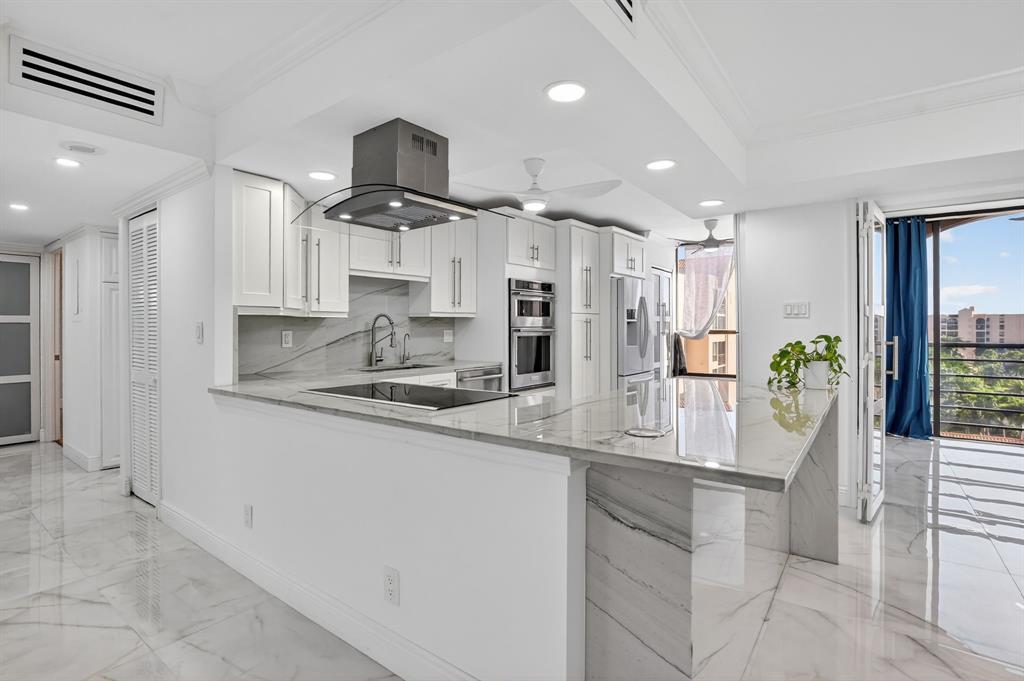 7145 Promenade Drive, Unit C702 Boca Raton, FL 33433 - Photo 24 of 82 a kitchen with stainless steel appliances kitchen island granite countertop a refrigerator and a stove top oven