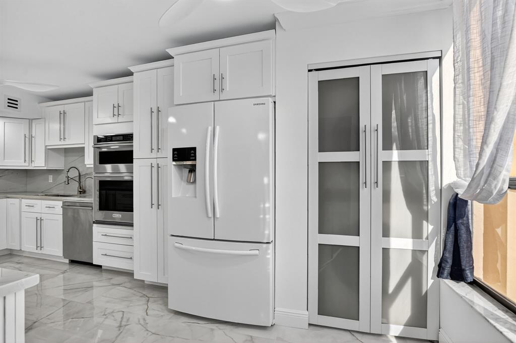 7145 Promenade Drive, Unit C702 Boca Raton, FL 33433 - Photo 32 of 82 a white refrigerator freezer and a stove sitting inside of a kitchen