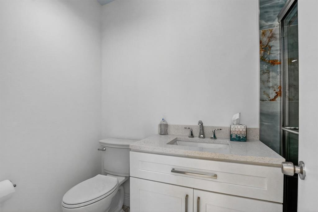 7145 Promenade Drive, Unit C702 Boca Raton, FL 33433 - Photo 79 of 82 a bathroom with a toilet sink vanity and mirror