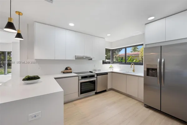 a kitchen with stainless steel appliances and white cabinets