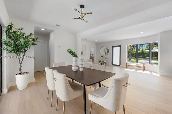 a view of a dining room with furniture and a potted plant